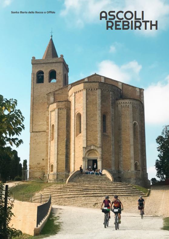 Ciclisti con sullo sfondo la chiesa di santa Maria della Rocca di Offida 