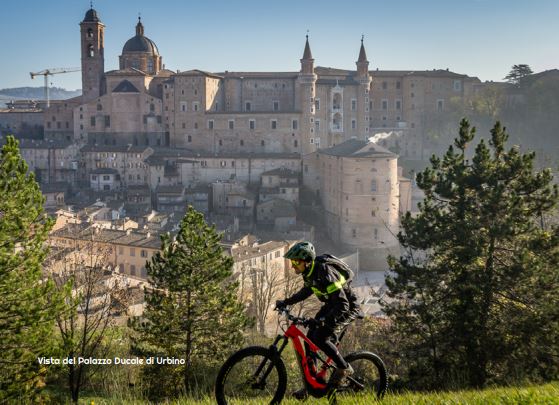 ciclista con sullo sfondo la città di Urbino